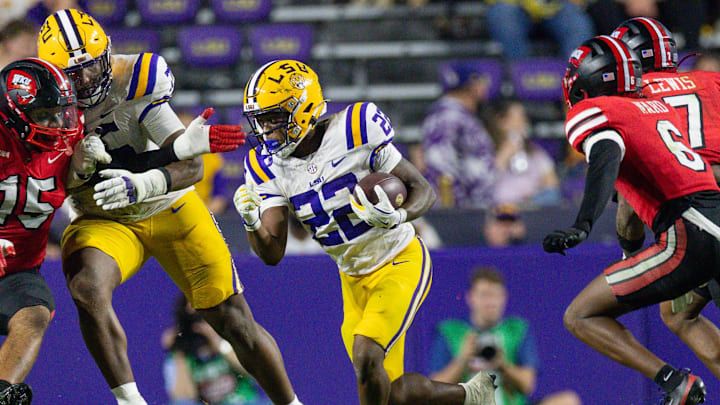 Nov 22, 2025; Baton Rouge, Louisiana, USA;  LSU Tigers running back Harlem Berry (22)] runs against Western Kentucky Hilltoppers defensive lineman Jayden Gray (15) during the second half at Tiger Stadium. Mandatory Credit: Stephen Lew-Imagn Images