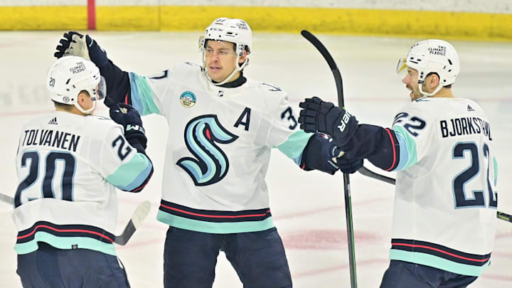 Nov 7, 2023; Tempe, Arizona, USA; Seattle Kraken right wing Eeli Tolvanen (20) celebrates with center Yanni Gourde (37) and right wing Oliver Bjorkstrand (22) after scoring a goal in the first period against the Arizona Coyotes at Mullett Arena. Mandatory Credit: Matt Kartozian-Imagn Images