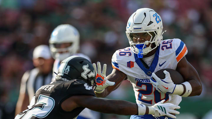 Aug 28, 2025; Tampa, Florida, USA; Boise State Broncos running back Sire Gaines (26) holds off South Florida Bulls cornerback De'Shawn Rucker (22) in the first quarter at Raymond James Stadium. 