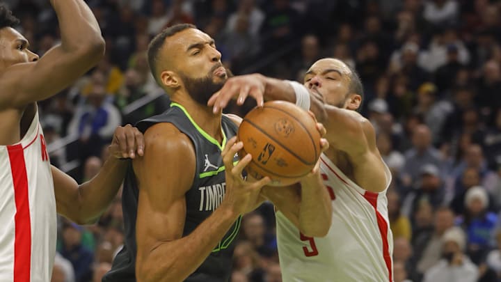 Nov 26, 2024; Minneapolis, Minnesota, USA; Minnesota Timberwolves center Rudy Gobert (27) grabs a rebound against Houston Rockets forward Dillon Brooks (9) it in the third quarter at Target Center. Mandatory Credit: Bruce Kluckhohn-Imagn Images