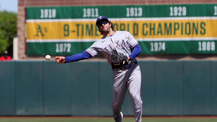 Texas Rangers second baseman Josh Smith throws to first base.