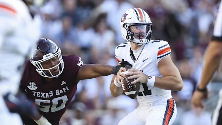 Sep 27, 2025; College Station, Texas, USA; Auburn Tigers quarterback Jackson Arnold (11) looks for an open receiver as Texas A&M Aggies defensive end Dayon Hayes (50) attemptst to make a tackle during the third quarter at Kyle Field. Mandatory Credit: Troy Taormina-Imagn Images