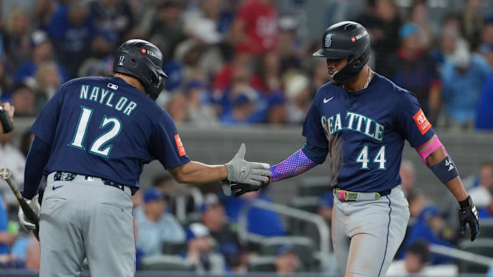 Oct 20, 2025; Toronto, Ontario, CAN; Seattle Mariners center fielder Julio Rodriguez (44) celebrates with first baseman Josh Naylor (12) after hitting a home run in the third inning against the Toronto Blue Jays during game seven of the ALCS round for the 2025 MLB playoffs at Rogers Centre.