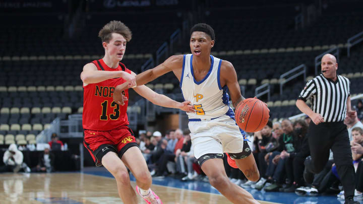 Lincoln Park's Meleek Thomas (5) drives to the basket while being guarded by North Catholic's Jason Fredericks (13) during the first half Wednesday night at PPG Paints Arena in Pittsburgh.