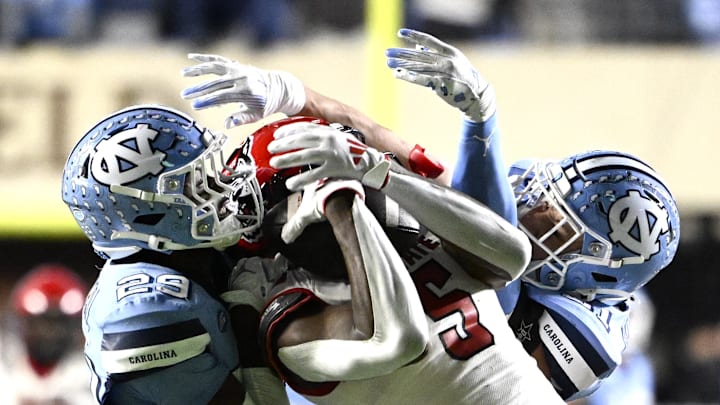 Nov 30, 2024; Chapel Hill, North Carolina, USA; North Carolina State Wolfpack wide receiver Noah Rogers (5) catches a 44 yard pass as North Carolina Tar Heels defensive backs Marcus Allen (29) and Will Hardy (31) defend in the fourth quarter at Kenan Memorial Stadium. Nov 30, 2024; Chapel Hill, North Carolina, USA; North Carolina State Wolfpack wide receiver Noah Rogers (5) catches a 44 yard pass as North Carolina Tar Heels defensive backs Marcus Allen (29) and Will Hardy (31) defend in the fourth quarter at Kenan Memorial Stadium.