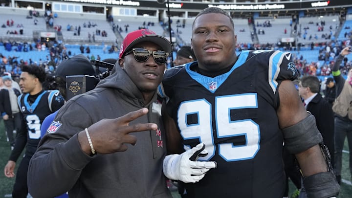 Jan 7, 2024; Charlotte, North Carolina, USA; Tampa Bay Buccaneers linebacker K.J. Britt (52) with Carolina Panthers defensive tackle Derrick Brown (95) after the game at Bank of America Stadium. 