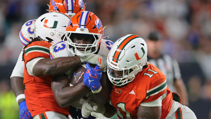 Sep 20, 2025; Miami Gardens, Florida, USA; Florida Gators running back Jadan Baugh (13) carries the football against Miami Hurricanes defensive lineman David Blay Jr. (11) during the third quarter at Hard Rock Stadium. Mandatory Credit: Sam Navarro-Imagn Images Sep 20, 2025; Miami Gardens, Florida, USA; Florida Gators running back Jadan Baugh (13) carries the football against Miami Hurricanes defensive lineman David Blay Jr. (11) during the third quarter at Hard Rock Stadium. Mandatory Credit: Sam Navarro-Imagn Images