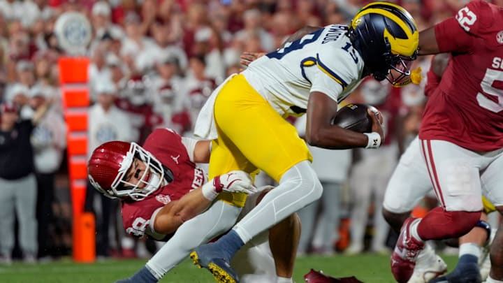 Oklahoma Sooners linebacker Owen Heinecke (38) brings down Michigan Wolverines quarterback Bryce Underwood (19) 