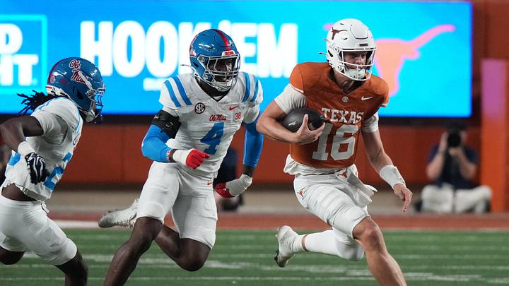 Texas Longhorns quarterback Arch Manning runs with the ball as Mississippi Rebels linebacker Suntarine Perkins pursues Texas Longhorns quarterback Arch Manning runs with the ball as Mississippi Rebels linebacker Suntarine Perkins pursues