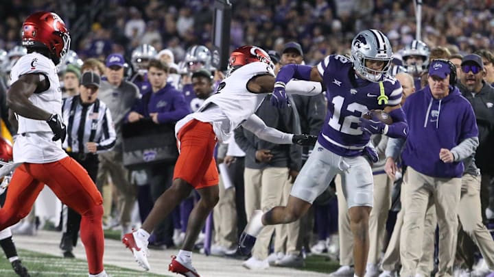 Nov 23, 2024; Manhattan, Kansas, USA; Kansas State Wildcats wide receiver Tre Spivey (12) is pushed out of bounds by Cincinnati Bearcats cornerback Ormanie Arnold (8) during the first quarter at Bill Snyder Family Football Stadium. Mandatory Credit: Scott Sewell-Imagn Images