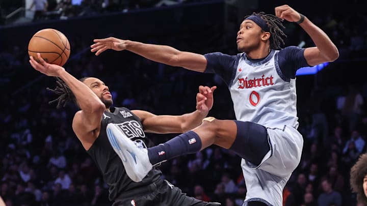Feb 5, 2025; Brooklyn, New York, USA;  Brooklyn Nets forward Tosan Evbuomwan (12) looks to drive past Washington Wizards guard Bilal Coulibaly (0) in the fourth quarter at Barclays Center. Mandatory Credit: Wendell Cruz-Imagn Images