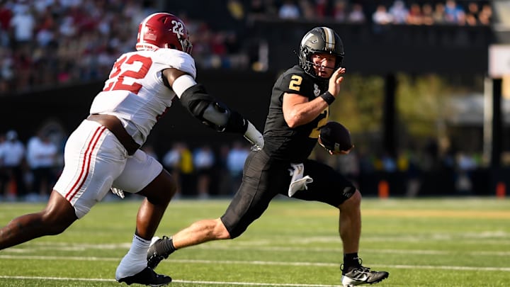 Oct 5, 2024; Nashville, Tennessee, USA;  Vanderbilt Commodores quarterback Diego Pavia (2) breaks the tackle of Alabama Crimson Tide defensive lineman LT Overton (22) during the first half at FirstBank Stadium. Mandatory Credit: Steve Roberts-Imagn Images