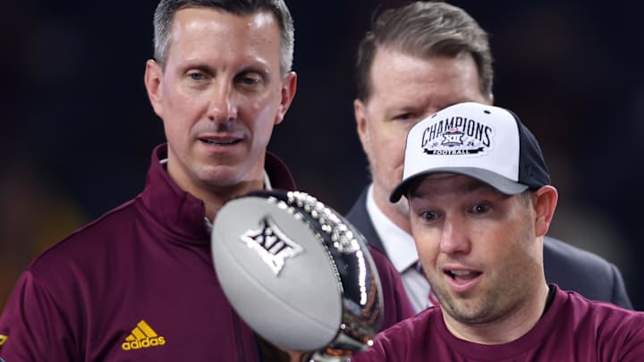 Dec 7, 2024; Arlington, TX, USA; Arizona State Sun Devils head coach Kenny Dillingham looks at the trophy after winning the Big 12 Championship game against the Iowa State Cyclones at AT&T Stadium. Mandatory Credit: Tim Heitman-Imagn Images Dec 7, 2024; Arlington, TX, USA; Arizona State Sun Devils head coach Kenny Dillingham looks at the trophy after winning the Big 12 Championship game against the Iowa State Cyclones at AT&T Stadium. Mandatory Credit: Tim Heitman-Imagn Images