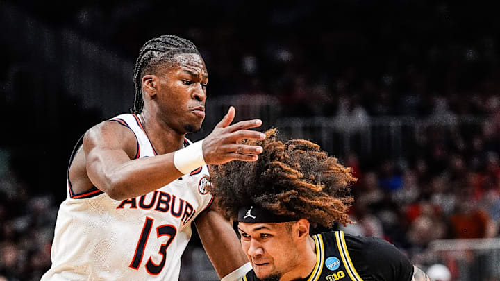 Michigan guard Tre Donaldson drives against an Auburn defender during an NCAA tournament game.