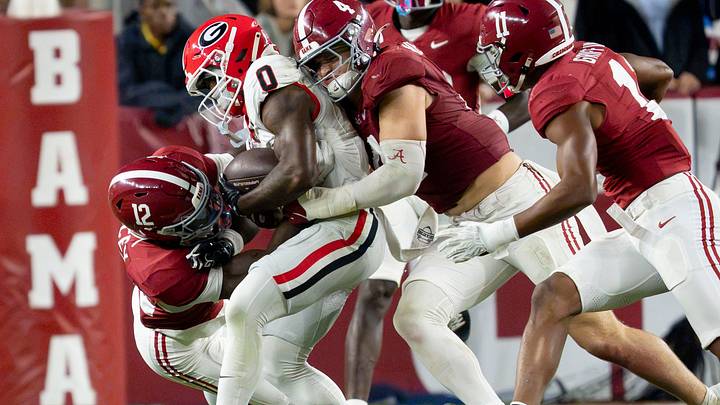 Oct 10, 2026; Tuscaloosa, Alabama, USA;  Alabama defensive back Zavier Mincey (12) and Alabama linebacker Luke Metz (4) combine to tackle Georgia wide receiver Sacovie White-Helton (0) at Saban Field at Bryant-Denny Stadium. Mandatory Credit: Gary Cosby Jr.-Imagn Images