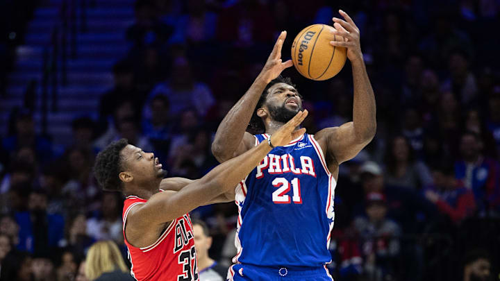 Jan 2, 2024; Philadelphia, Pennsylvania, USA; Philadelphia 76ers center Joel Embiid (21) and Chicago Bulls forward Terry Taylor (32) reach for a loose ball during the third quarter at Wells Fargo Center. Mandatory Credit: Bill Streicher-Imagn Images