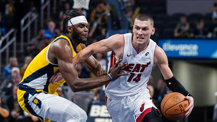 Nov 15, 2024; Indianapolis, Indiana, USA; Miami Heat guard Tyler Herro (14) dribbles the ball while Indiana Pacers forward Jarace Walker (5) defends in the second half at Gainbridge Fieldhouse. Mandatory Credit: Trevor Ruszkowski-Imagn Images