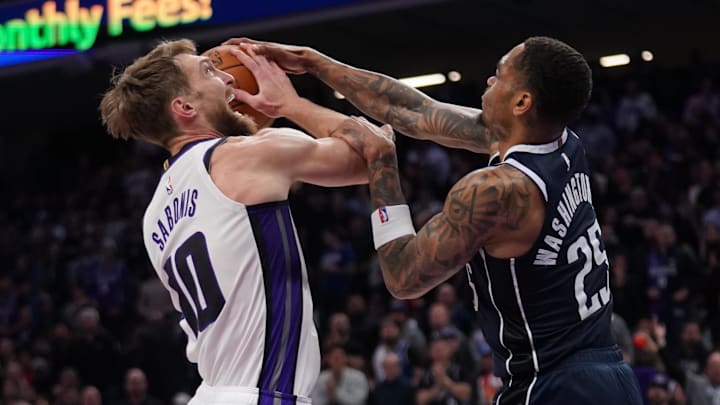 Mar 29, 2024; Sacramento, California, USA; Sacramento Kings forward Domantas Sabonis (10) has the ball knocked out of his hands by Dallas Mavericks forward P.J. Washington (25) in the fourth quarter at the Golden 1 Center.