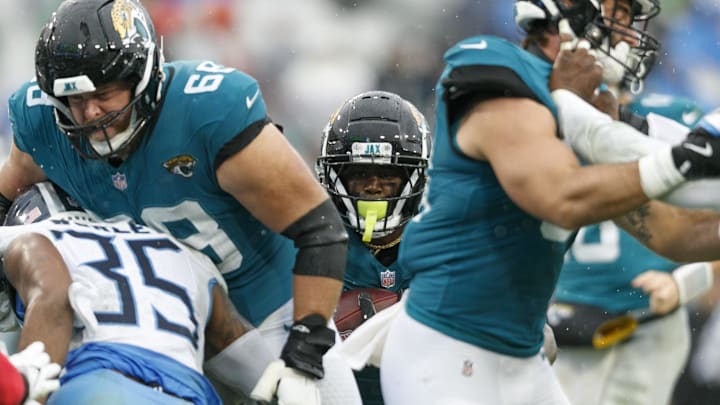 Dec 29, 2024; Jacksonville, Florida, USA; Jacksonville Jaguars running back Travis Etienne Jr. (1) runs the ball behind offensive line Brandon Scherff (68) and Tennessee Titans cornerback Daryl Worley (35) during the second quarter at EverBank Stadium. Mandatory Credit: Morgan Tencza-Imagn Images
