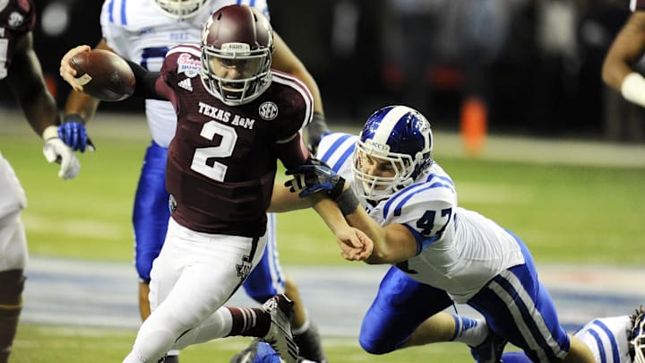Dec 31, 2013; Atlanta, GA, USA;  Texas A&M Aggies quarterback Johnny Manziel (2) carries the ball past Duke Blue Devils linebacker David Helton (47) during the third quarter in the 2013 Chick-fil-a Bowl at the Georgia Dome. Mandatory Credit: Dale Zanine-USA TODAY Sports
