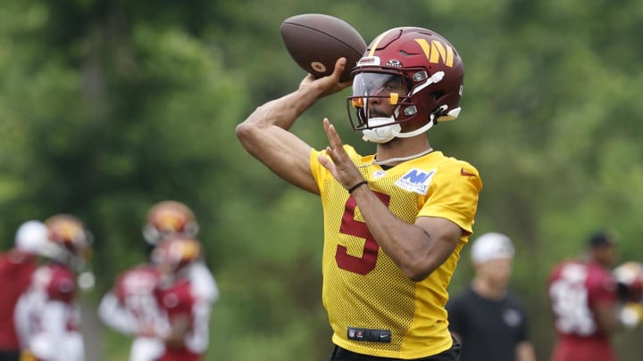Jun 5, 2024; Ashburn, VA, USA; Washington Commanders quarterback Jayden Daniels (5) passes a ball during an OTA workout at Commanders Park.  