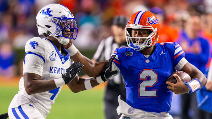 Florida Gators quarterback DJ Lagway (2) stiff arms Kentucky Wildcats defensive back Kristian Story (4) during the first half at Ben Hill Griffin Stadium in Gainesville, FL on Saturday, October 19, 2024 against the Kentucky Wildcats. [Doug Engle/Gainesville Sun]