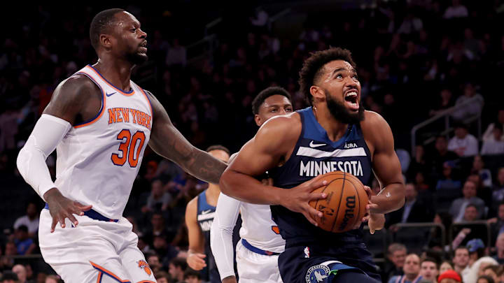 Oct 14, 2023; New York, New York, USA; Minnesota Timberwolves center Karl-Anthony Towns (32) drives to the basket against New York Knicks forward Julius Randle (30) and guard RJ Barrett (9) during the first quarter at Madison Square Garden. Mandatory Credit: Brad Penner-Imagn Images