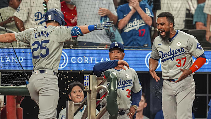 Sep 15, 2024; Cumberland, Georgia, USA; Los Angeles Dodgers shortstop Tommy Edman (25) is hit with seeds by left fielder Teoscar Hernandez (37) after hitting a home run against the Atlanta Braves during the ninth inning at Truist Park. Mandatory Credit: Dale Zanine-Imagn Images