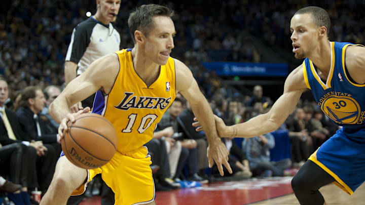 Oct 18, 2013; Shanghai, China; Los Angeles Lakers guard Steve Nash (10) dribbles the ball as Golden State Warriors guard Stephen Curry (30) defends during the first quarter at Mercedes-Benz Arena. Mandatory Credit: Danny La-Imagn Images