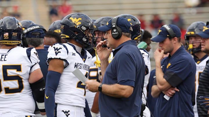 Nov 1, 2025; Houston, Texas, USA; West Virginia Mountaineers head coach Rich Rodriguez talks to wide receiver Cam Vaughn (4) during an official timeout against the Houston Cougars in the first half at TDECU Stadium. Mandatory Credit: Thomas Shea-Imagn Images Nov 1, 2025; Houston, Texas, USA; West Virginia Mountaineers head coach Rich Rodriguez talks to wide receiver Cam Vaughn (4) during an official timeout against the Houston Cougars in the first half at TDECU Stadium. Mandatory Credit: Thomas Shea-Imagn Images