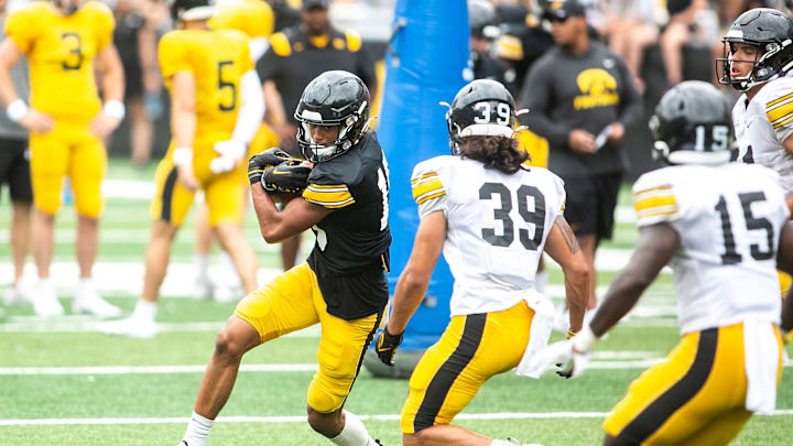 Iowa wide receiver Jacob Bostick, left, gets tackled by linebacker Eric Epenesa (39) during the Kids