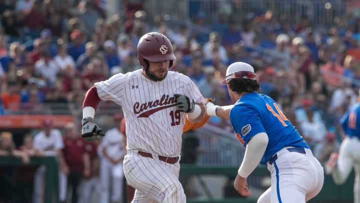 Gators utility Jac Caglianone (14) with the catch at first for the out against Gamecocks catcher Cole Messina (19) in Game 2 of the NCAA Super Regional against Florida, Saturday, June 10, 2023, at Condron Family Ballpark in Gainesville, Florida. The Gators beat the Gamecocks 4-0 and are headed to the College World Series in Omaha.  [Cyndi Chambers/ Gainesville Sun] 2023