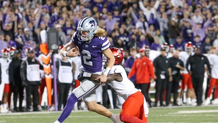 Nov 23, 2024; Manhattan, Kansas, USA; Cincinnati Bearcats linebacker Jiquan Sanks (9) tries to tackle Kansas State Wildcats quarterback Avery Johnson (2) during the first quarter at Bill Snyder Family Football Stadium. Johnson scored a touchdown on the play. Mandatory Credit: Scott Sewell-Imagn Images