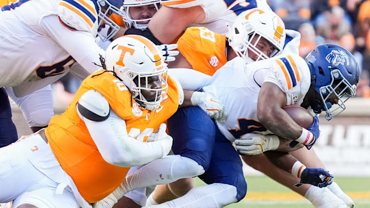 Tennessee defensive lineman Elijah Simmons (10) and Tennessee defensive lineman Daevin Hobbs (53) take down UTEP running back Jevon Jackson (4) during a college football game between Tennessee and UTEP at Neyland Stadium in Knoxville, Tenn., Saturday, Nov. 23, 2024.