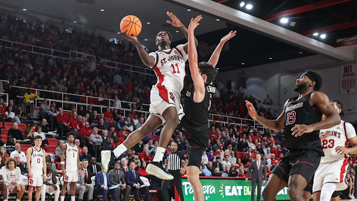 Dec 23, 2025; Queens, New York, USA;  St. John's basketball guard Ian Jackson (11) drives past Harvard Crimson guard Ben Eisendrath (5) in the second half at Carnesecca Arena.
