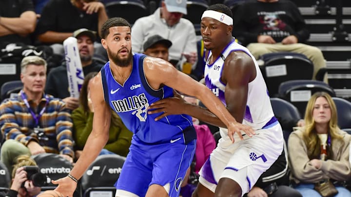 Oct 13, 2025; Salt Lake City, Utah, USA; Dallas Mavericks forward/center Jeremiah Robinson-Earl (23) looks for an open man during the second half while being guarded by Utah Jazz forward/center Oscar Tshiebwe (34) at Delta Center. Mandatory Credit: Peter Creveling-Imagn Images