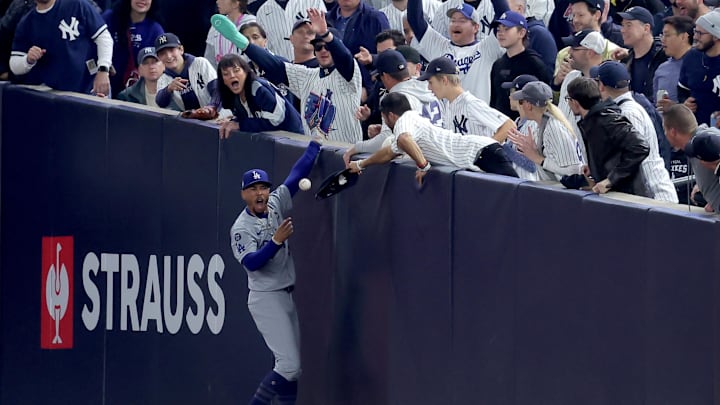 Oct 29, 2024; New York, New York, USA; Los Angeles Dodgers shortstop Mookie Betts (50) makes a catch in foul territory as a New York Yankees fan interferes during the first inning in game four of the 2024 MLB World Series at Yankee Stadium. Mandatory Credit: Brad Penner-Imagn Images