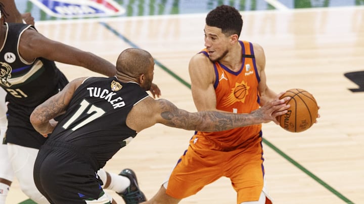 Milwaukee Bucks forward P.J. Tucker defends Phoenix Suns guard Devin Booker.