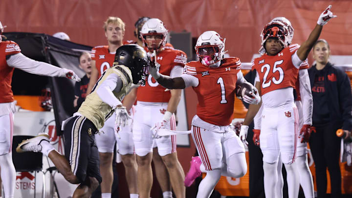 Utah Utes running back Wayshawn Parker (1) runs against Colorado Buffaloes defensive back John Slaughter (13) during the second half at Rice-Eccles Stadium.