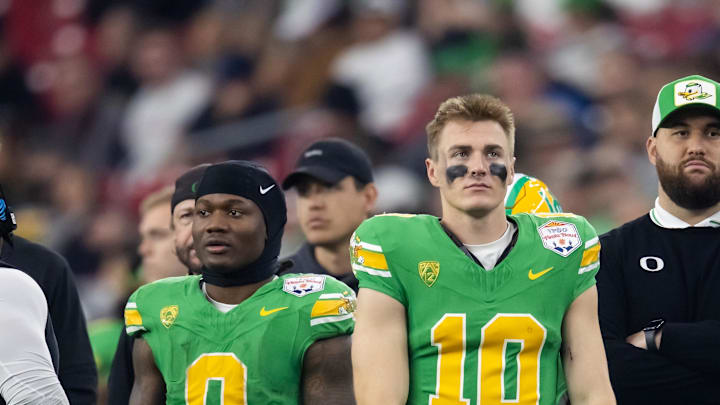 Jan 1, 2024; Glendale, AZ, USA; Oregon Ducks running back Bucky Irving (0) and quarterback Bo Nix (10) against the Liberty Flames during the 2024 Fiesta Bowl at State Farm Stadium. Mandatory Credit: Mark J. Rebilas-Imagn Images