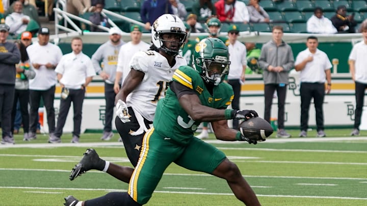 Nov 1, 2025; Waco, Texas, USA; Baylor Bears safety DJ Coleman (33) makes an interception in front of UCF Knights wide receiver Waden Charles (19) during the second half at McLane Stadium. Mandatory Credit: Raymond Carlin III-Imagn Images