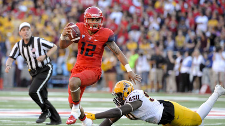 Nov 28, 2014; Tucson, AZ, USA; Arizona Wildcats quarterback Anu Solomon (12) runs the ball as Arizona State Sun Devils defensive lineman Tashon Smallwood (90) pursues during the fourth quarter of the territorial cup at Arizona Stadium. Arizona won 42-35. Mandatory Credit: Casey Sapio-Imagn Images