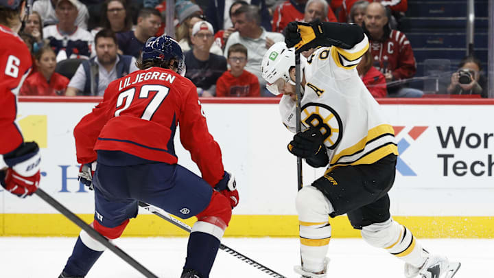 Mar 9, 2026; Washington, District of Columbia, USA; Boston Bruins right wing David Pastrnak (88) attempts to skate with the puck past Washington Capitals defenseman Timothy Liljegren (27) during the second period at Capital One Arena. Mandatory Credit: Geoff Burke-Imagn Images