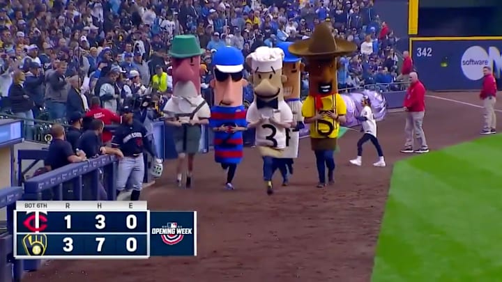 Byron Buxton walks onto the field as the Famous Racing Sausages at American Family Field sprint past.