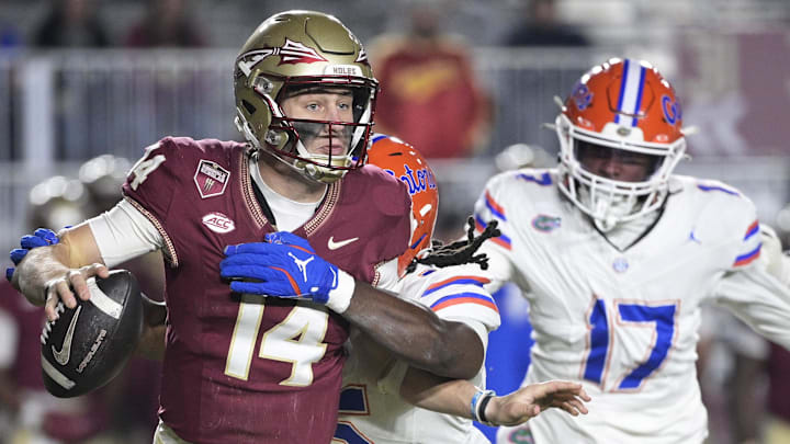 Nov 30, 2024; Tallahassee, Florida, USA; Florida State Seminoles quarterback Luke Kromenhoek (14) is pressured by Florida Gators linebacker Myles Graham (5) during the second half at Doak S. Campbell Stadium. Mandatory Credit: Melina Myers-Imagn Images