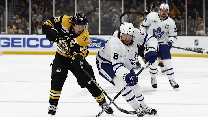 Oct 26, 2024; Boston, Massachusetts, USA; Boston Bruins left wing Brad Marchand (63) and Toronto Maple Leafs defenseman Chris Tanev (8) battle for a loose puck during the first period at TD Garden. Mandatory Credit: Winslow Townson-Imagn Images