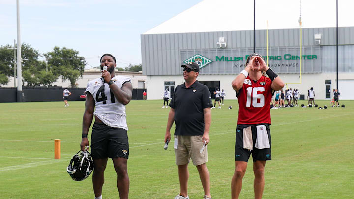Jul 26, 2024; Jacksonville, FL, USA;  Jacksonville Jaguars quarterback Trevor Lawrence (16) and linebacker Josh Hines-Allen (41) speak to fans during training camp at Miller Electric Center. Mandatory Credit: Nathan Ray Seebeck-Imagn Images