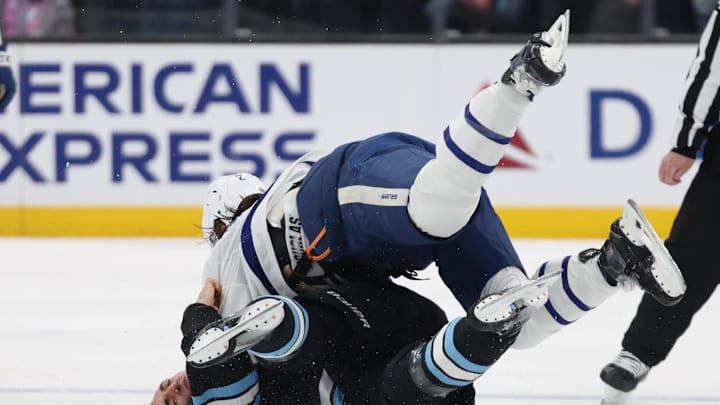 Mar 10, 2025; Salt Lake City, Utah, USA; Utah Hockey Club defenseman Michael Kesselring (7) and Toronto Maple Leafs defenseman Simon Benoit (2) fight during the second period at Delta Center. Mandatory Credit: Rob Gray-Imagn Images