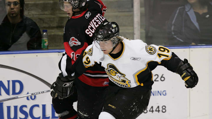 Oct 23, 2005; Mississauga, ON, CANADA; FILE PHOTO; Kingston Frontenacs centre (19) Bobby Hughes drives Mississuaga Icedogs forward (13) Drew Schiestel into the boards during OHL action at the Hershey Centre in Mississauga. Hughes is ranked 25th by NHL Central Scouting for the 2006 draft. Mandatory Credit: Photo By John Sokolowski- Imagn Images © Copyright John Sokolowski