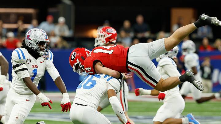 Jan 1, 2026; New Orleans, LA, USA; Mississippi Rebels safety Wydett Williams Jr. (16) tackles Georgia Bulldogs quarterback Gunner Stockton (14) in the third quarter during the 2026 Sugar Bowl and quarterfinal game of the College Football Playoff at Caesars Superdome. Mandatory Credit: Geoff Burke-Imagn Images